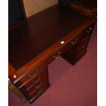 A late Victorian mahogany twin pedestal writing desk, having a tan rexine inset writing surface over