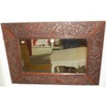 An Eastern floral relief carved teak framed rectangular wall mirror, 65x92cm