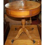 A reproduction yew wood low circular pedestal drum occasional table, having opposing drawers, dia.