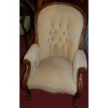 A Victorian rosewood showframe armchair, having pale fabric button back upholstery, raised on