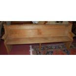 A pine twin panelled long church pew with faceted detail, width 207cm