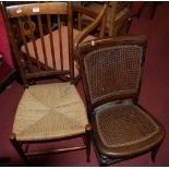 A 1920s oak caneback open armchair; together with a Victorian carved oak and red upholstered pad