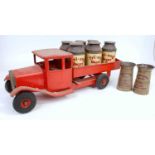 A large scale Triang pressed steel model of an open back dairy truck finished in red with matching
