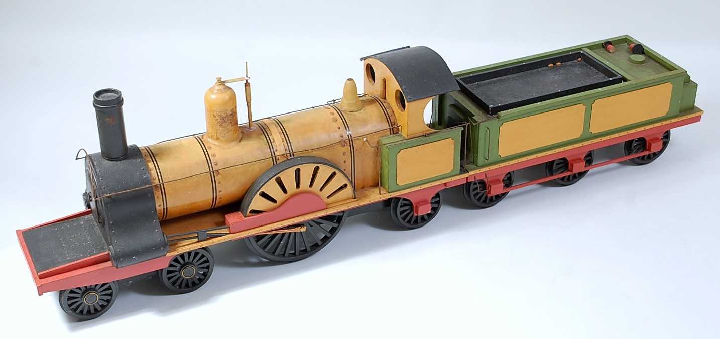 A wooden scratch built model of a 4-2-2 locomotive and six wheel tender, finished in orange, red and