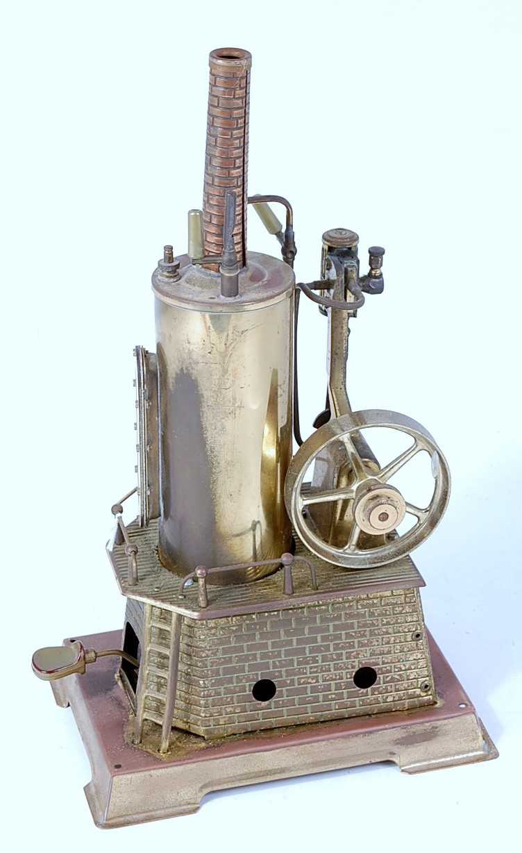 A Wilesco solid brass vertical steam engine, comprising brickwork housed vertical boiler powering