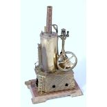 A Wilesco solid brass vertical steam engine, comprising brickwork housed vertical boiler powering