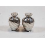 A pair of Victorian silver cruets each of wrythen form with pierced covers, gross weight 3.6oz