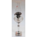 An early 20th century silver plated oil lamp, having cut glass reservoir on a tapered, with