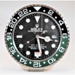 A modern wall clock, the dial in the form of a Rolex GMT Master II Superlative Chronometer, having