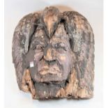 A Native American carved softwood mask of a tribal elder wearing eagle headdress, polychrome