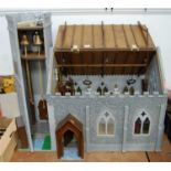 A hand made model of an old style church, complete with figures and accessories, having opening roof