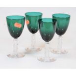 A set of four green tinted drinking glasses, each having a knopped textured stem and circular foot