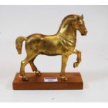 A gilt metal model of a Tang horse, on rectangular wooden plinth, h.28cm