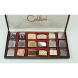 A Colibri pocket cigarette lighter display case containing 15 various Colibri cigarette lighters