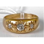 A late Victorian 18ct gold diamond three-stone ring, each being gypsy set, the centre old cut