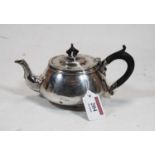 A 1930s silver bachelors teapot, of squat circular form, having ebonised finial and handle. retailed