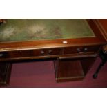 A reproduction mahogany and gilt tooled green leather inset twin pedestal writing desk (some