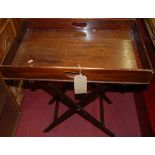 A 19th century mahogany butler's tray raised on folding stand