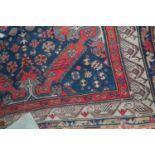 A Persian woollen blue ground Shiraz rug (with some wear to ground, and losses to borders), 390 x