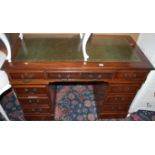 A contemporary mahogany and gilt tooled green leather inset twin pedestal writing desk, having