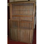 A reclaimed panelled pine side cupboard, having twin glazed upper doors enclosing shelved interior