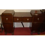 A Regency style mahogany and crossbanded twin pedestal sideboard, having lion mask ring handles