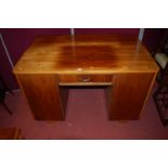 An Art Deco walnut round cornered kneehole writing desk, having single central frieze drawer flanked