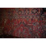 A Persian woollen red ground Shiraz rug (with some wear and fading to ground), 330 x 250cm