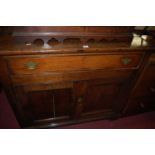 An early 19th century provincial oak double door side cupboard, having single long frieze drawer,
