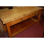 A pine plank topped long kitchen preparation table, having twin frieze drawers, on square supports