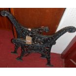 A pair of black painted cast iron bench ends, each of floral pierced and shaped form