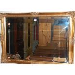 A contemporary floral gilt decorated bevelled rectangular wall mirror, 73.5 x 104cm