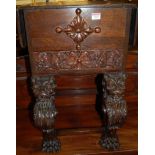 An early 20th century Continental carved oak dropflap hinge topped work table, raised on mask and