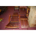 A pair of stained and slatted teak folding steamer chairs
