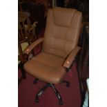 A contemporary chrome and tan leather upholstered swivel desk armchair having rise and fall