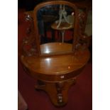 A mid-Victorian mahogany demi-lune swing mirrorback 'Duchess' dressing table, having floral carved