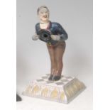 A late 19th century cast iron mechanical figural cigar cutter in the form of a waiter, wearing