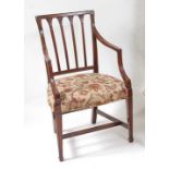 A George III mahogany elbow chair, the back with leaf carved reeded uprights over a stuffover