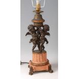 *A circa 1900 French bronze and marble table lamp, modelled as a pair of winged cherubs upon a