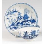 A Lowestoft porcelain tea bowl and saucer, underglaze blue painted in the Fence & Pagoda pattern,
