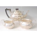 A late Victorian silver three-piece tea set, comprising teapot, twin handled sugar, and cream,