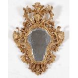 *An 18th century carved giltwood pier glass, having a shaped and bevelled plate flanked by three