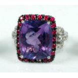 A white metal, amethyst, ruby and diamond oblong cluster ring, featuring a centre cushion cut