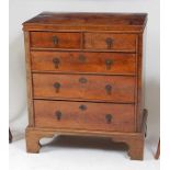 An antique walnut and oyster veneered chest, of small proportions, having pine sides and carcass,