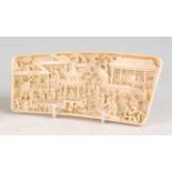 A late 19th century Chinese relief carved ivory wrist rest, intricately carved with raised and