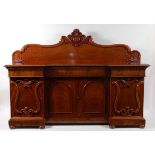 A Victorian mahogany inverted breakfront sideboard, having central blind frieze drawer over cupboard