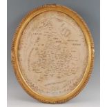 An early 19th century needlework sampler county map of England and Wales, within trailing floral