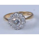 An 18ct yellow and white gold diamond circular cluster ring, featuring a large centre round