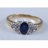 An 18ct yellow and white gold, sapphire and diamond ring, featuring a centre oval faceted sapphire