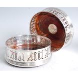 A pair of modern silver wine bottle coasters, each having a pierced gallery and on turned hardwood